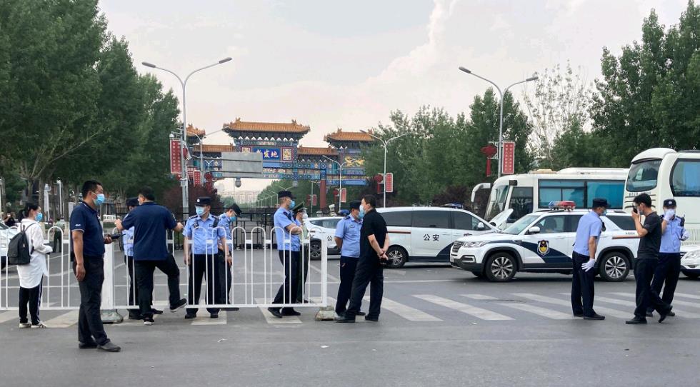 新发地批发市场外戴着口罩的警察和其他人员