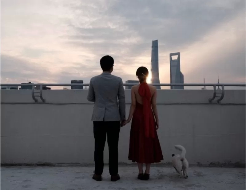 一对新婚夫妇在住宅区一栋建筑物的屋顶上合影留念