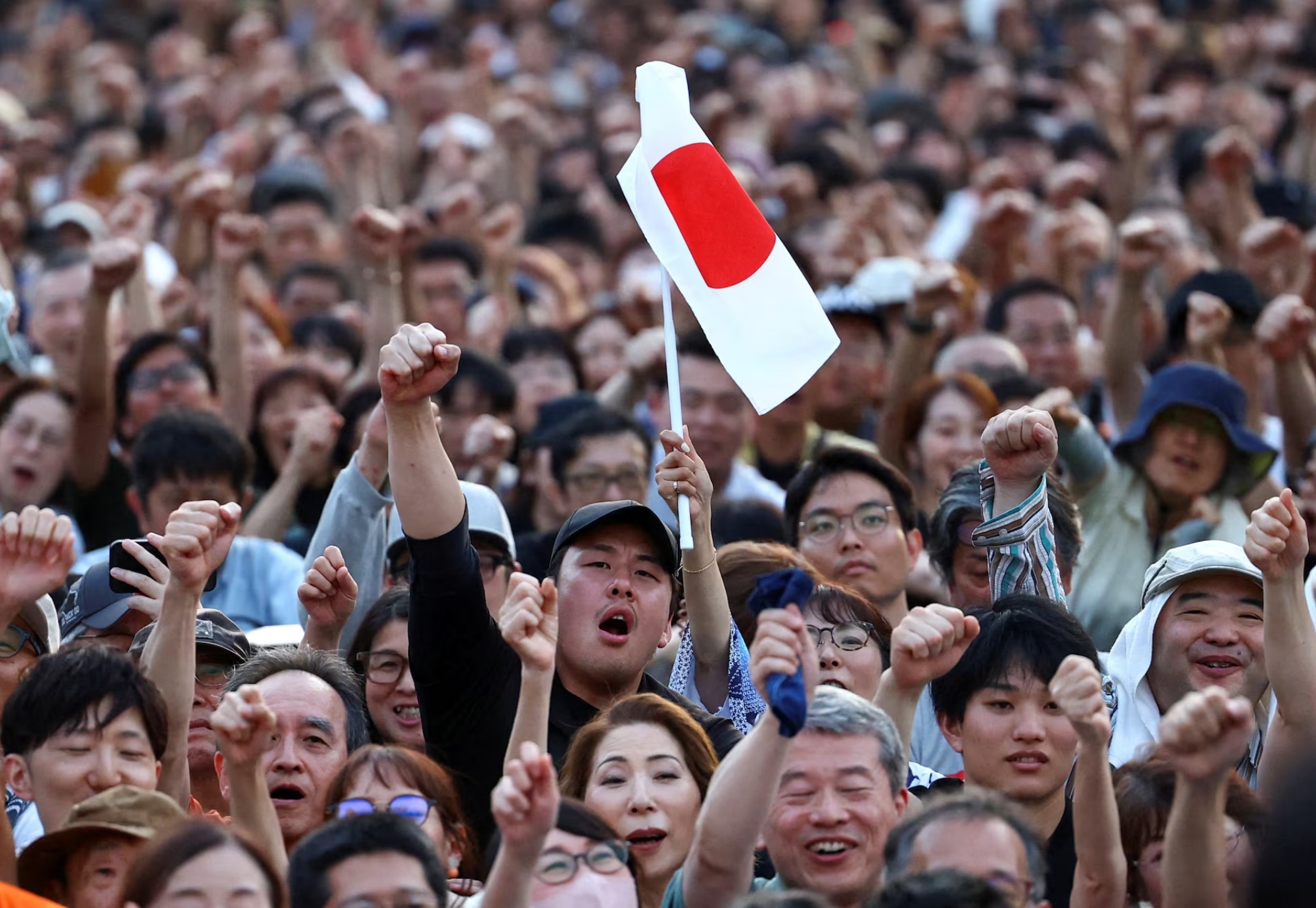 参政党支持者在东京芝公园的参政党竞选之旅中举起拳头