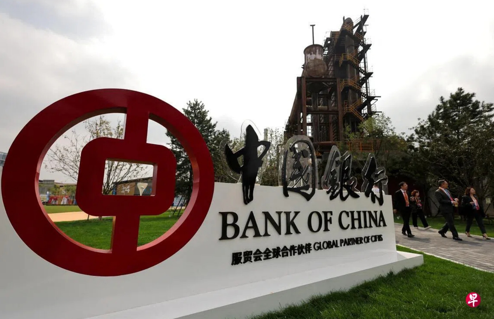图为去年9月10日，在中国北京首钢公园举行的服贸会会场，人们走过中国银行的标志 ...